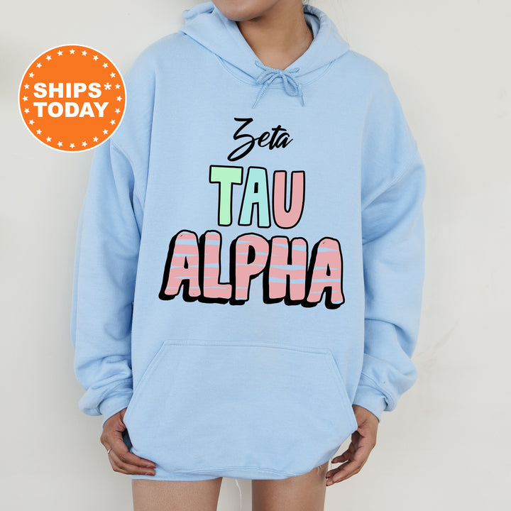 a person wearing a blue hoodie with the words tau alpha printed on it