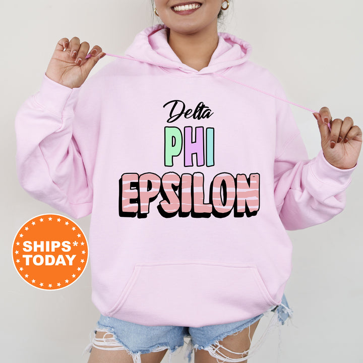 a woman wearing a pink hoodie that says delta phi epsilon