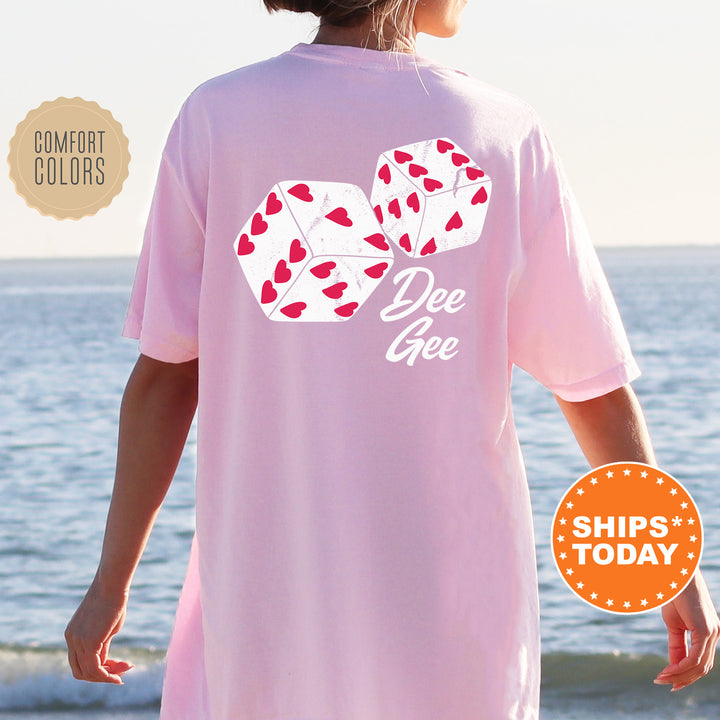 a woman standing on a beach wearing a pink shirt