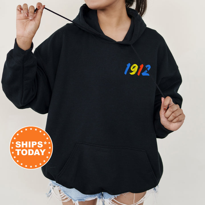 a woman wearing a black hoodie with a rainbow number on it