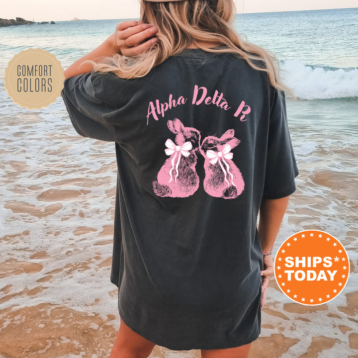 a woman standing on a beach wearing a black shirt