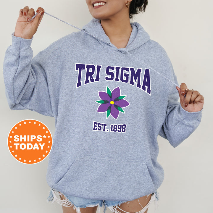 a woman wearing a blue sweatshirt with a flower on it