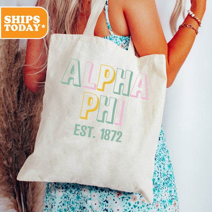 a woman holding a white tote bag with the words alplia plu