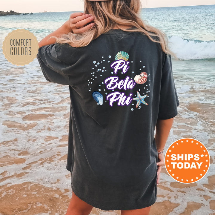 a woman standing on a beach wearing a black shirt