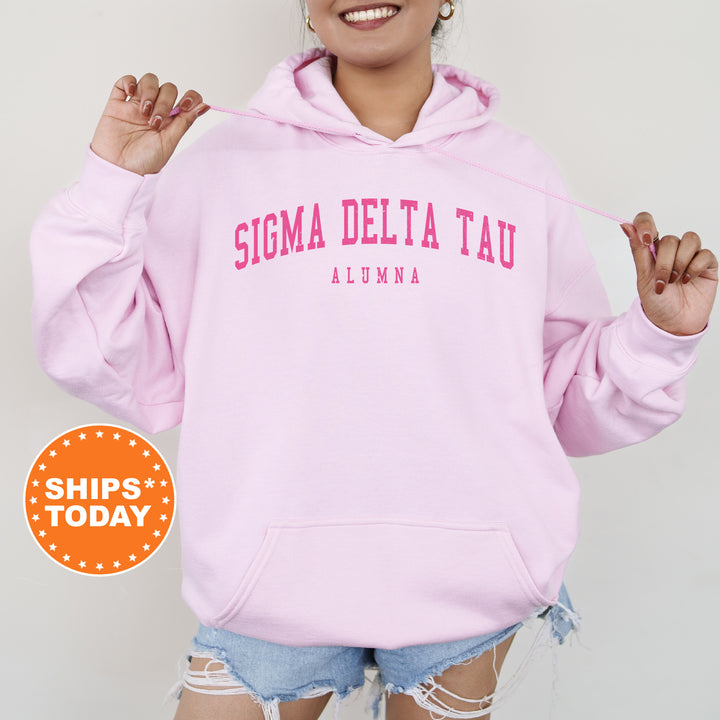 a woman wearing a pink hoodie that says stigmaa delta tau