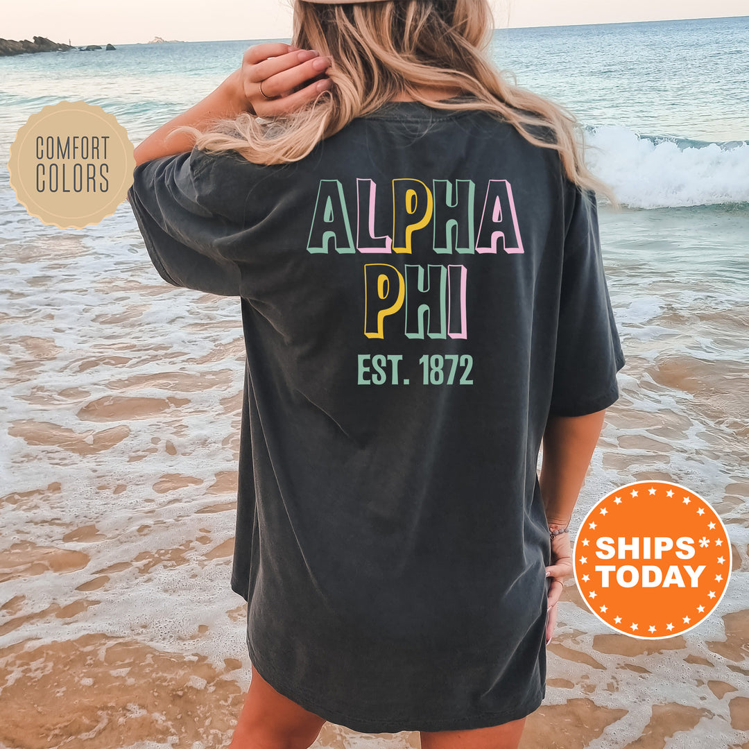 a woman standing on a beach wearing a black shirt