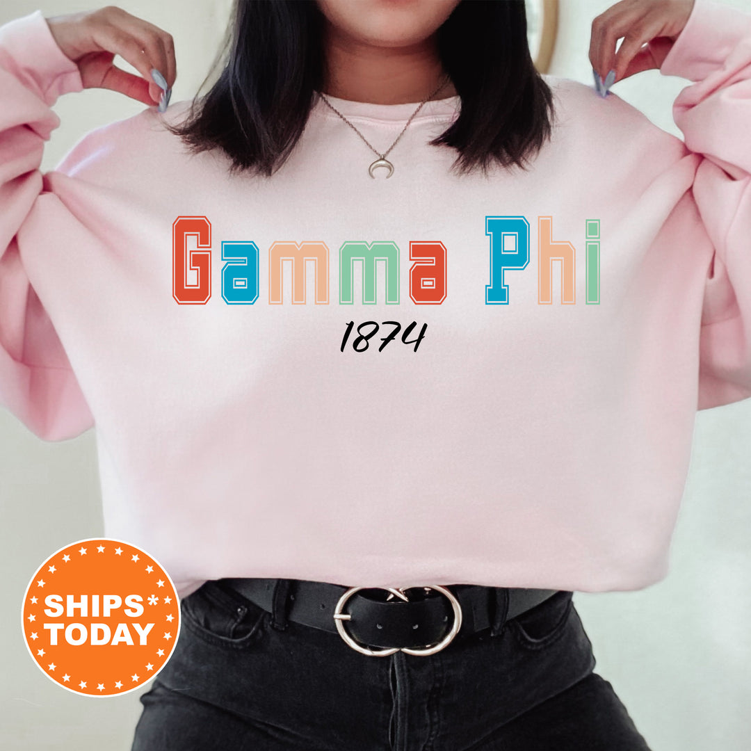 a woman wearing a pink sweatshirt with the words gumma phi printed on it