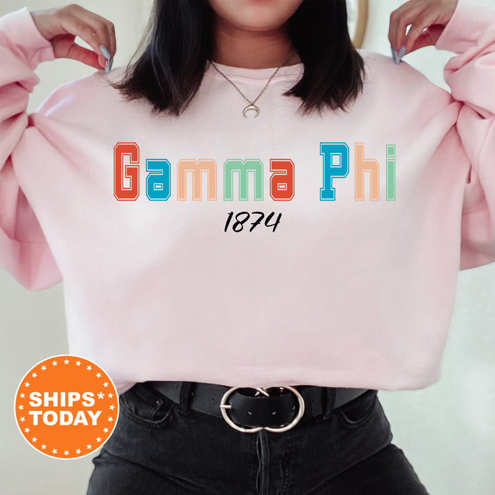 a woman wearing a pink sweatshirt with the words gumma phi printed on it
