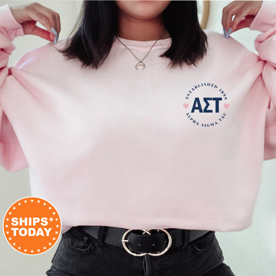 a woman wearing a pink sweatshirt with a blue and white logo on it