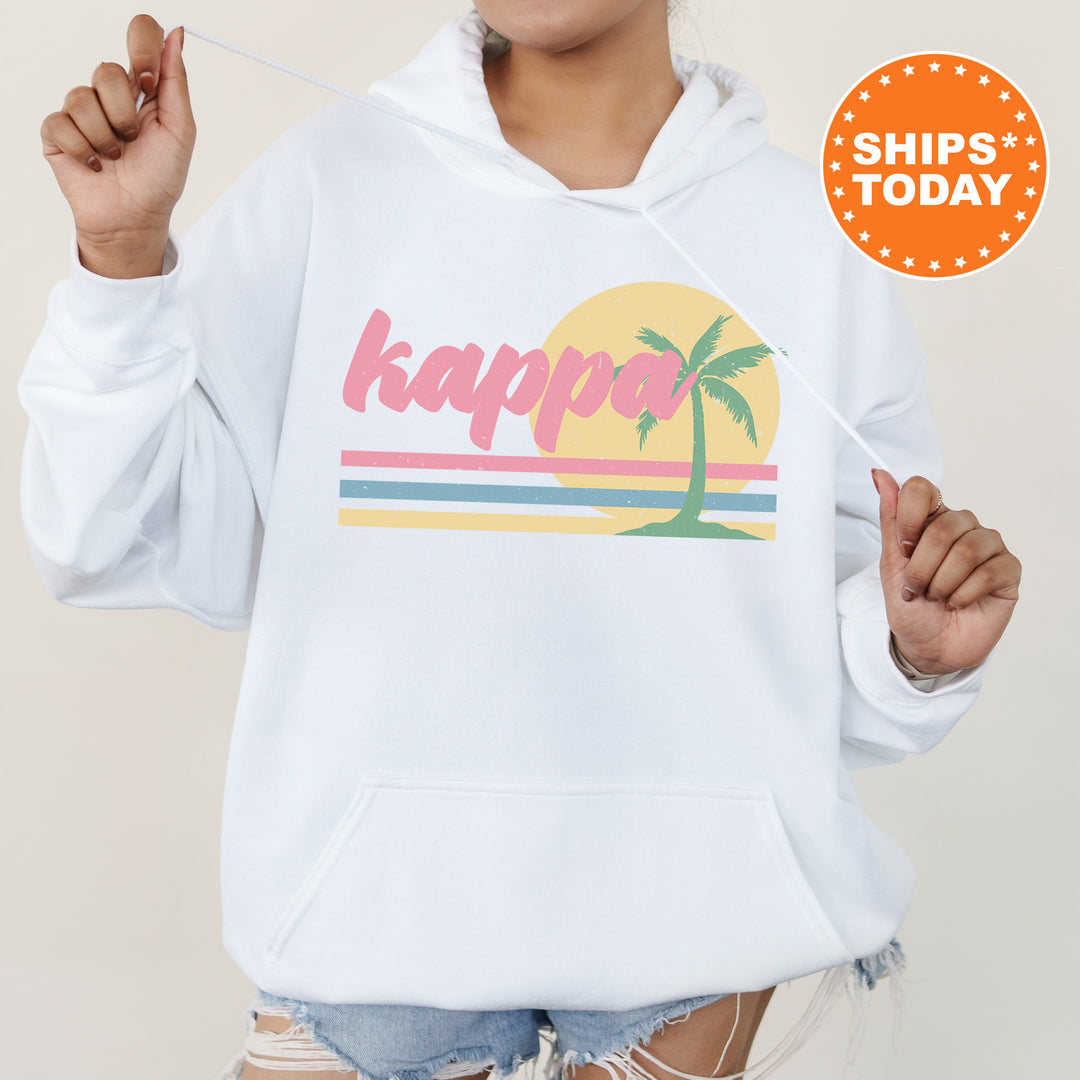 a woman wearing a white hoodie with a palm tree on it