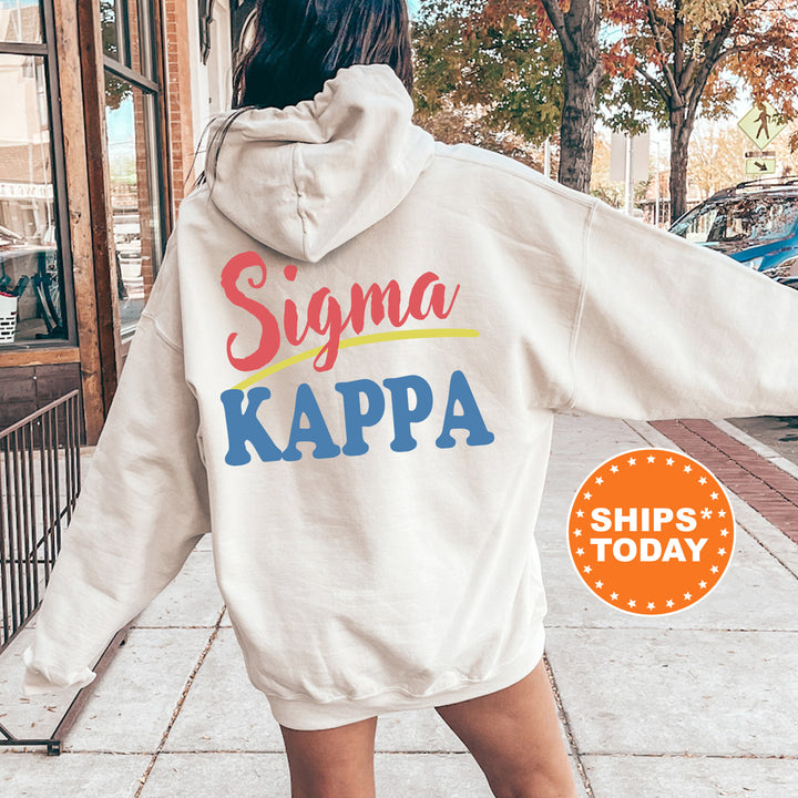A person wearing a white hoodie with the Sigma Kappa logo printed on it, standing on a sidewalk.