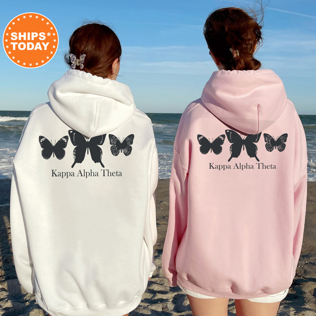 two women wearing butterfly sweatshirts on the beach