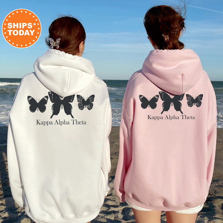 two women wearing butterfly sweatshirts on the beach