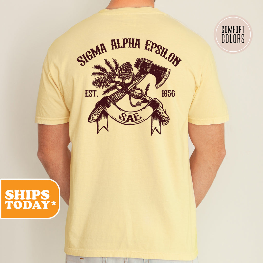 a man wearing a yellow shirt with an image of guns and pine cones on it