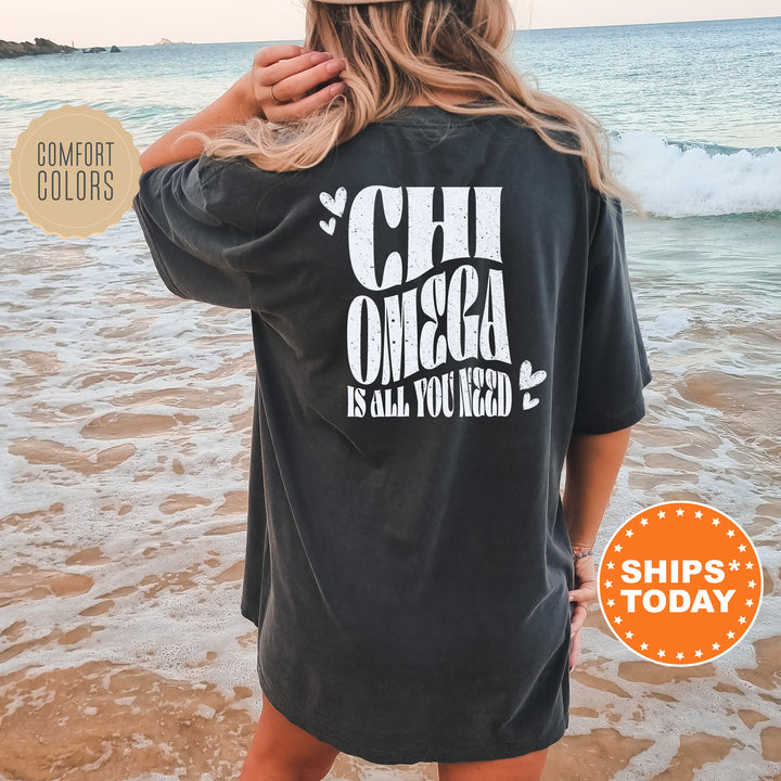 a woman standing on a beach wearing a black shirt