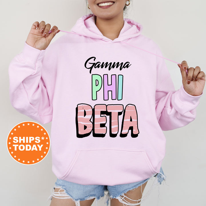 a woman wearing a pink hoodie that says gama phi beta