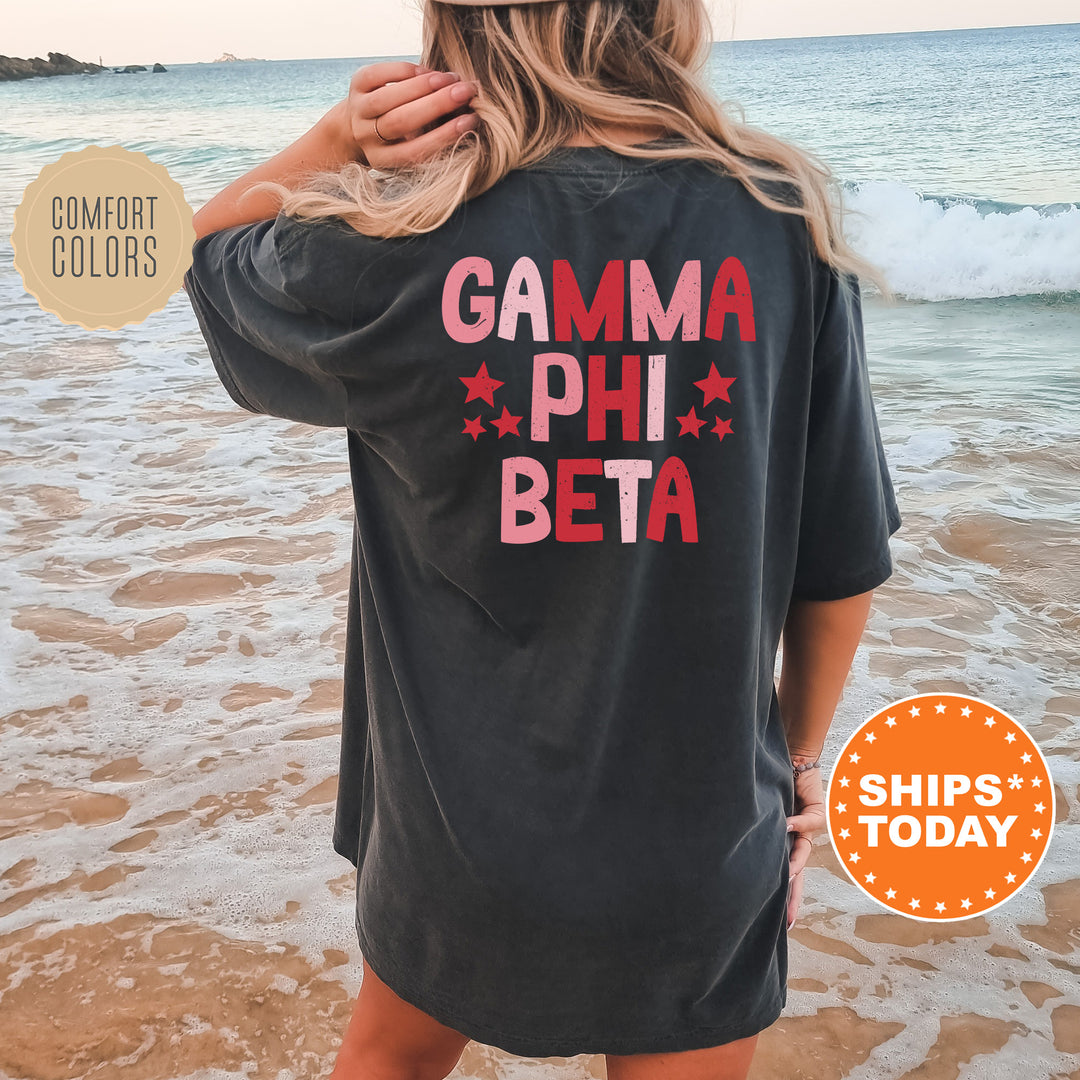 a woman standing on the beach wearing a gama phi beta shirt