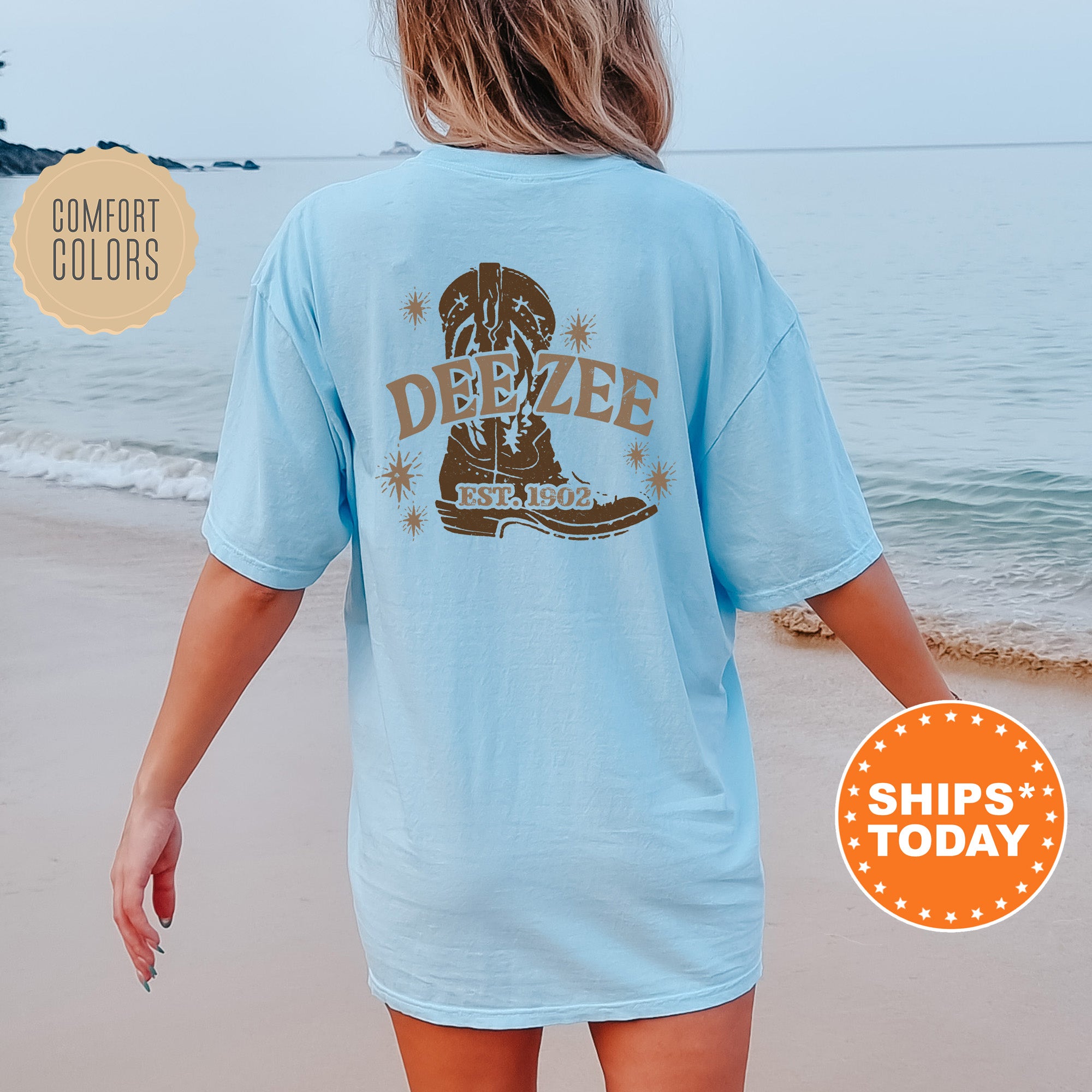 a woman walking on the beach wearing a blue shirt