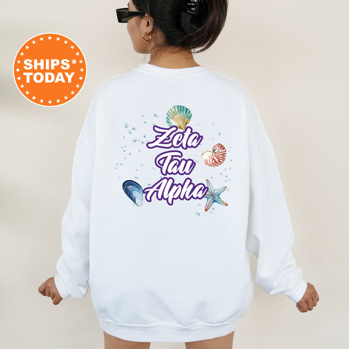 a woman wearing a white sweatshirt with the words zero tail aloha printed on