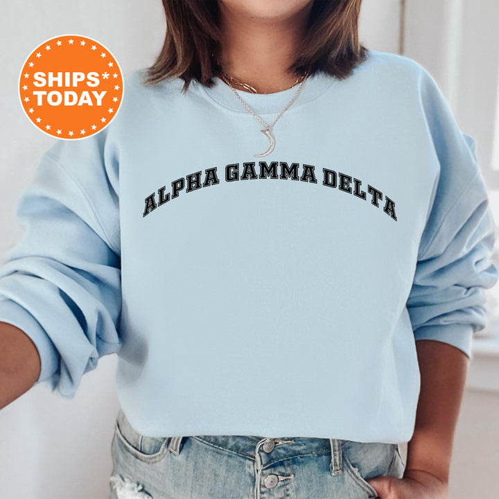 a woman wearing a light blue sweatshirt with the words, alpha gama delta on