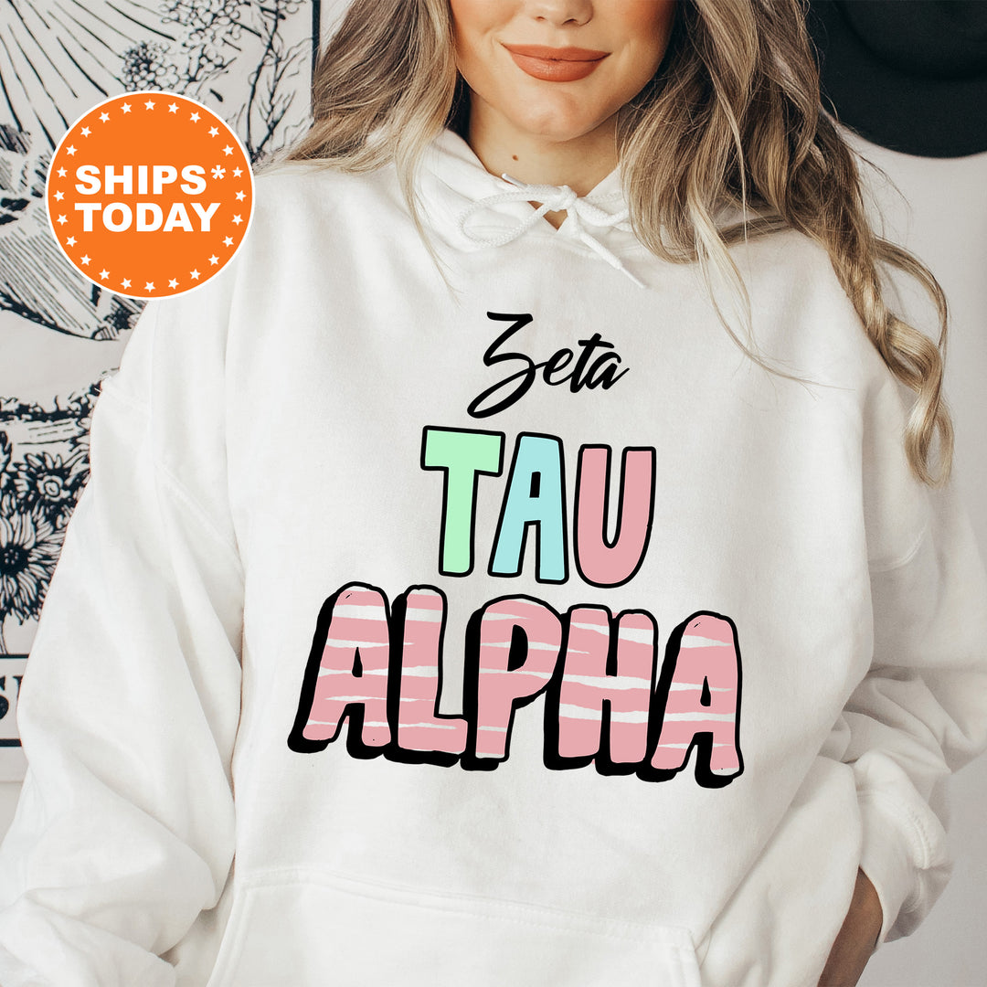 a woman wearing a white hoodie that says zetta tau alpha