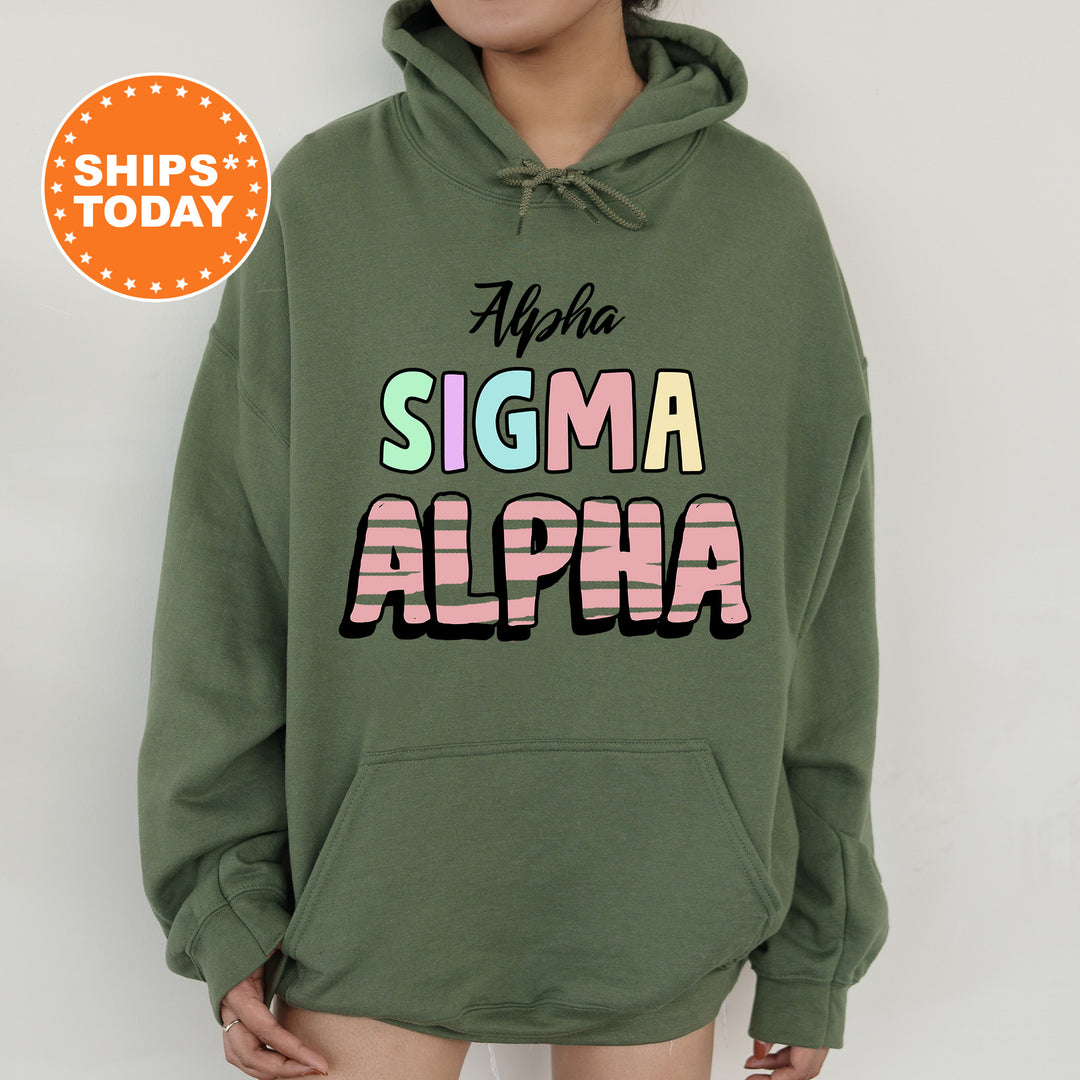 a woman wearing a green hoodie with the words stigmaa alpha on it