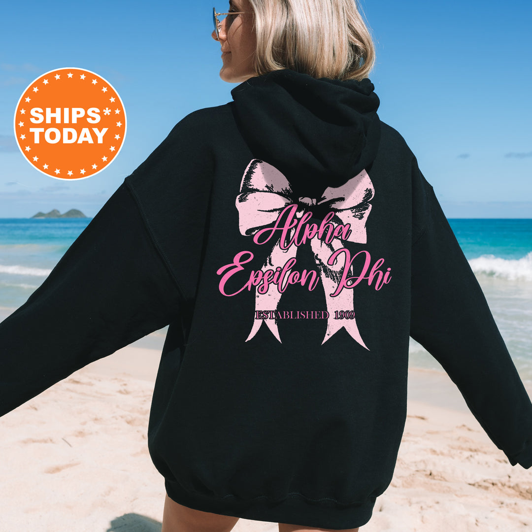 a woman in a black hoodie is walking on the beach