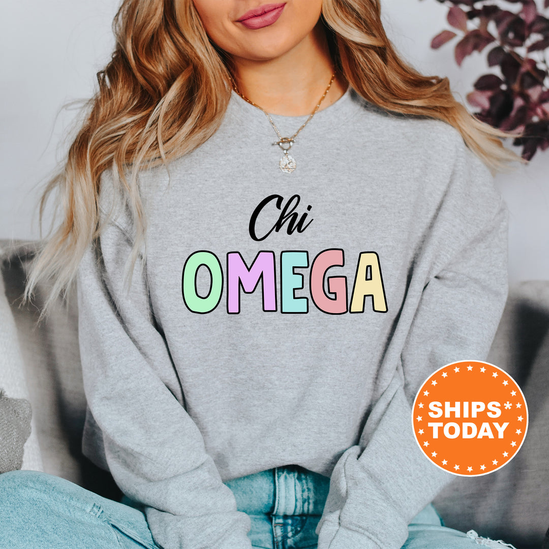 a woman sitting on a couch wearing a sweatshirt that says oh omega