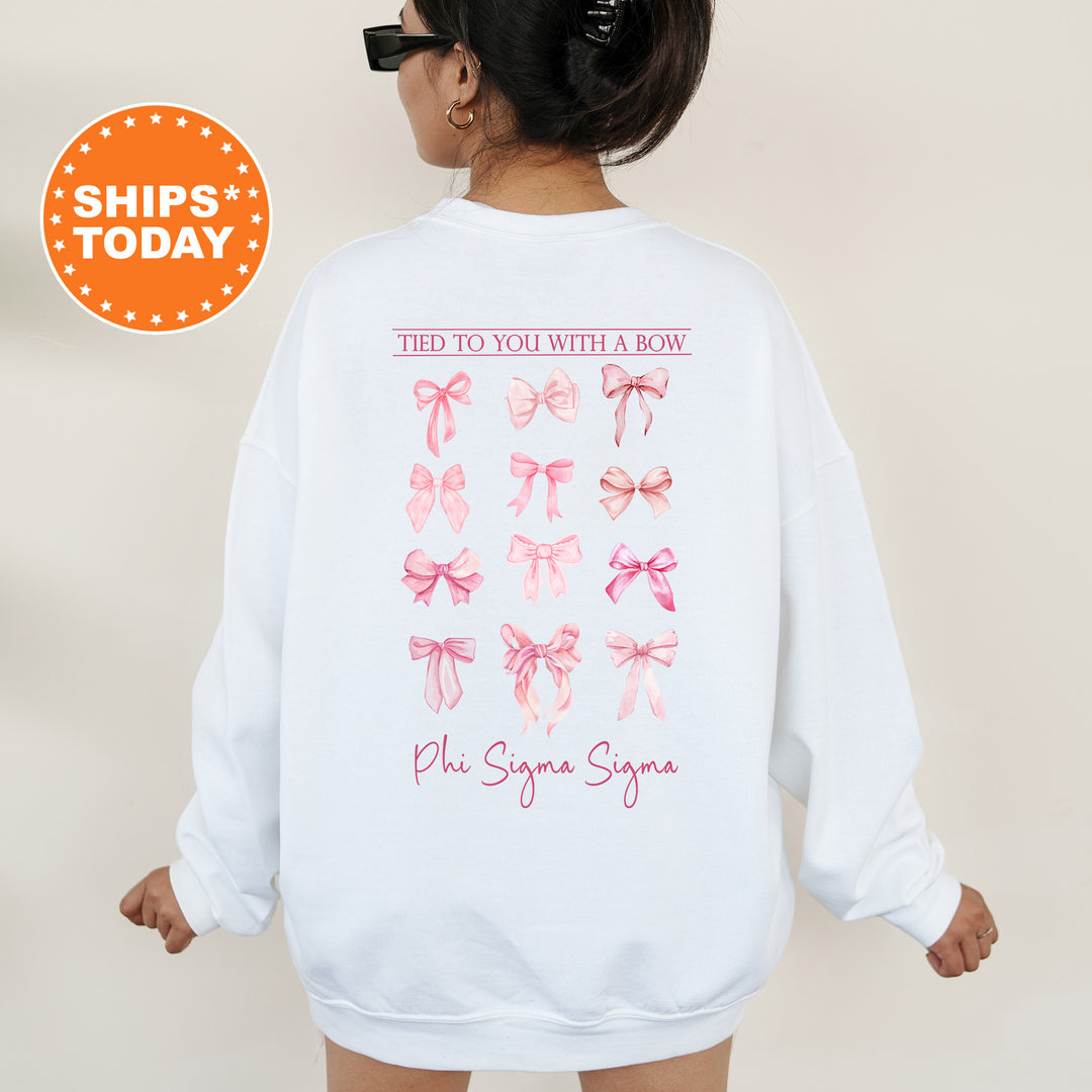 A person wearing a white sweatshirt with a graphic design of pink bows on the back.