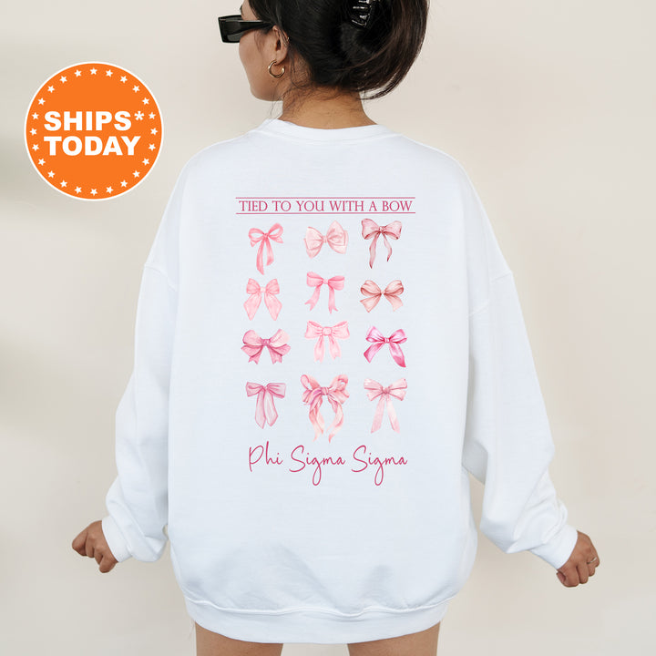 A person wearing a white sweatshirt with a graphic design of pink bows on the back.