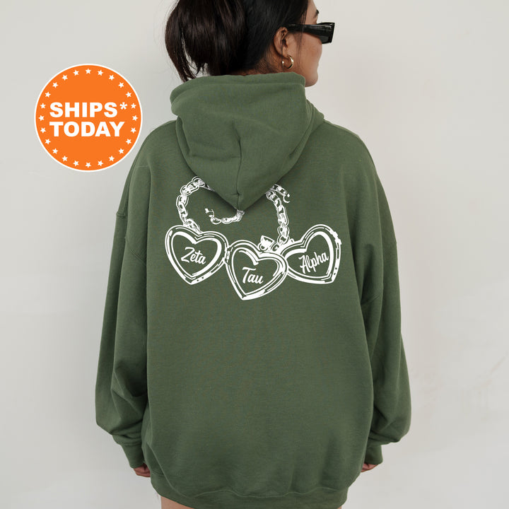 A person wearing a green hoodie with white text and heart designs on the back.