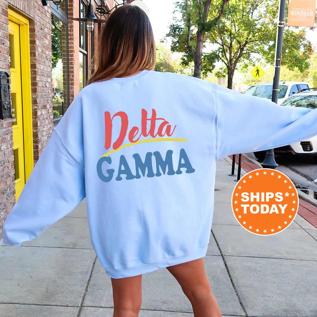 A woman wearing a blue sweatshirt with the Delta Gamma sorority logo on the back is standing on a sidewalk.