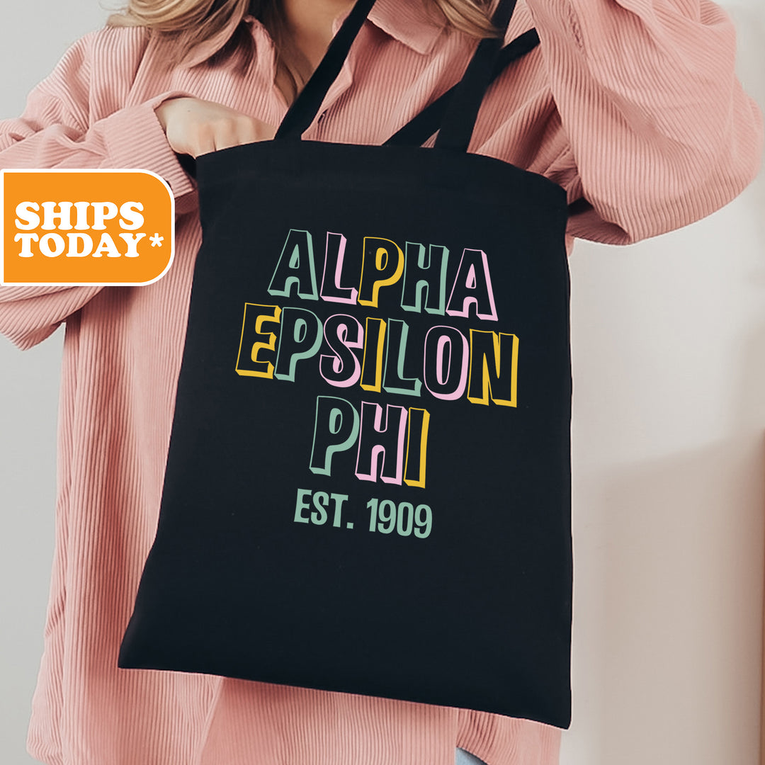 a woman holding a black tote bag with the words, alpha epsion phi