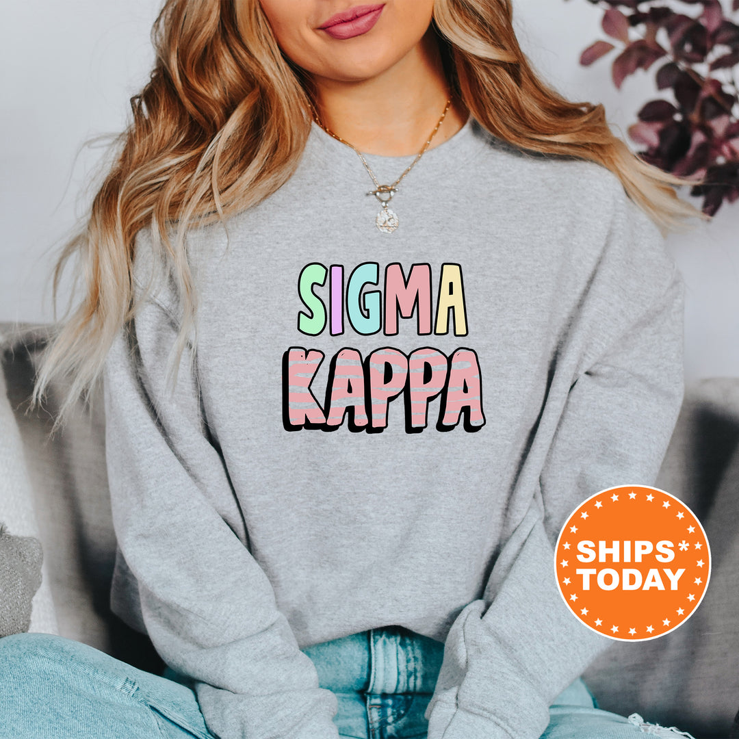 a woman sitting on a couch wearing a sweatshirt that says stigmaa kappa