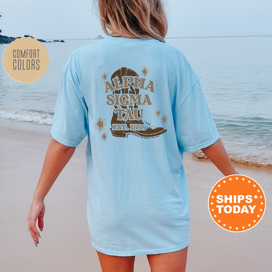 a woman walking on the beach wearing a blue shirt