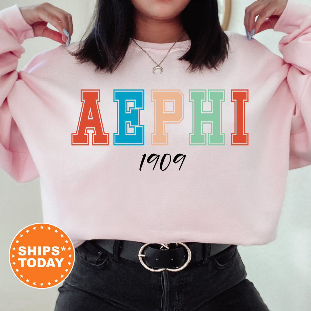 a woman wearing a pink sweatshirt with the word aephi printed on it