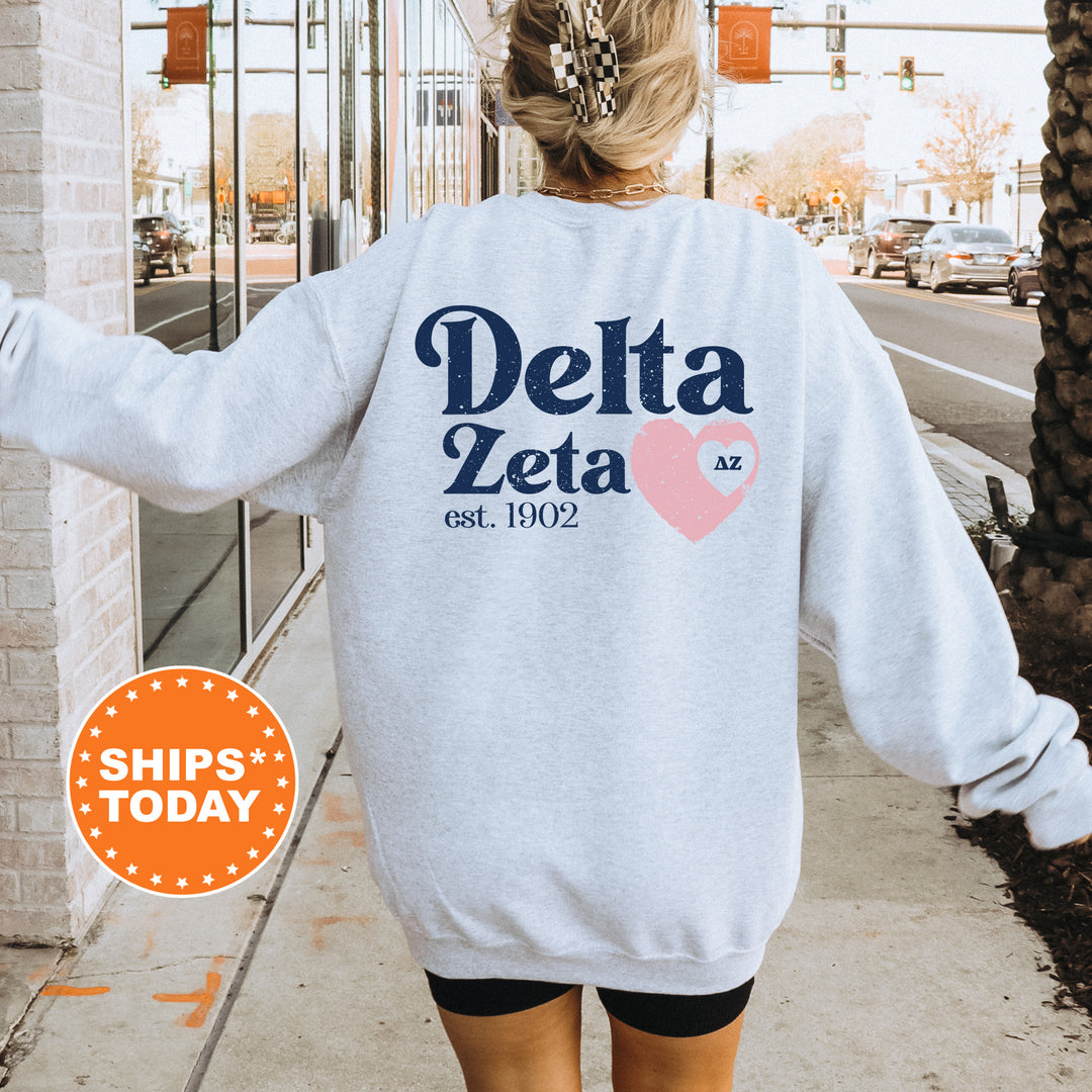 a woman walking down a sidewalk wearing a delta sweatshirt