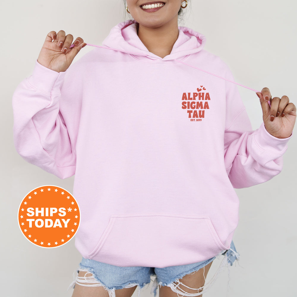 a woman wearing a pink hoodie with the words alpaa sigma