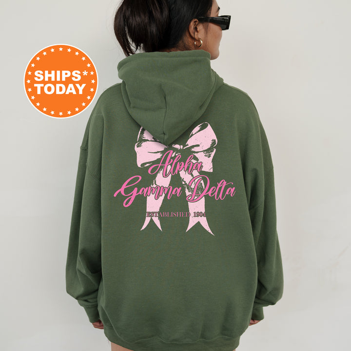 a woman wearing a green sweatshirt with a pink bow on it