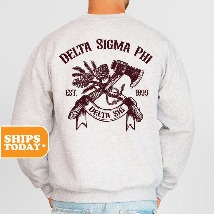 a man wearing a sweatshirt with a hammer and pine cone on it