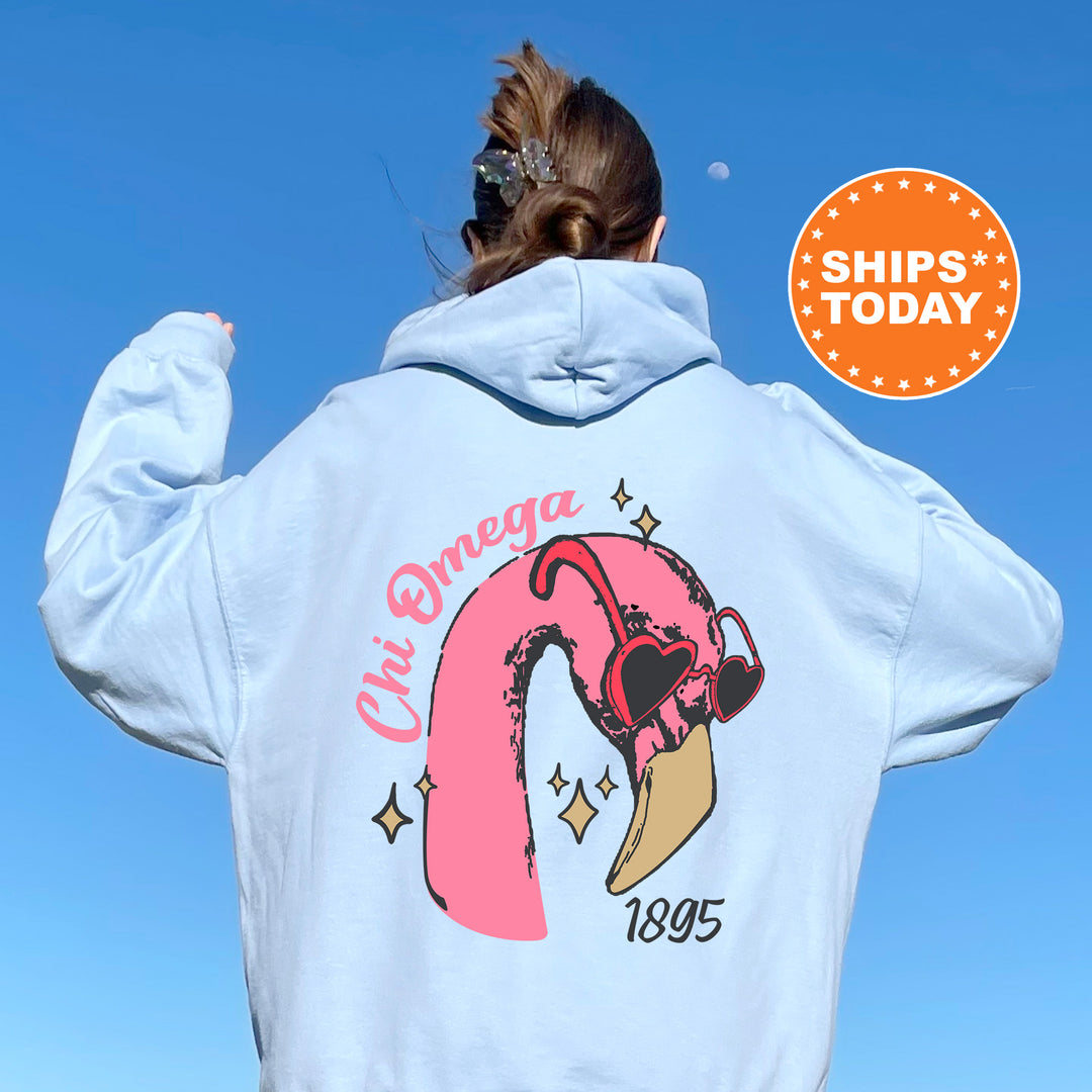 a woman wearing a white sweatshirt with a pink flamingo on it