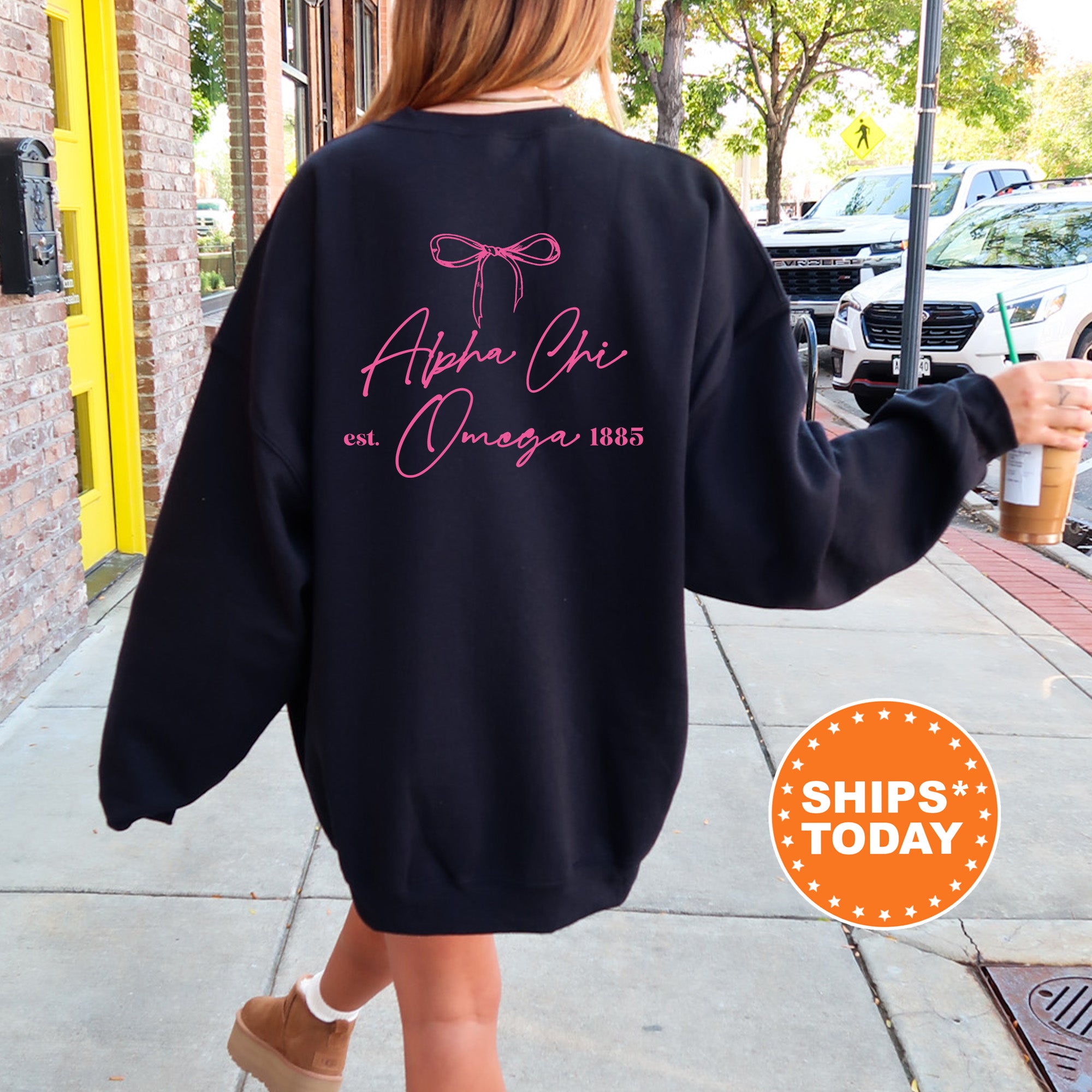 a woman walking down a sidewalk wearing a black sweatshirt