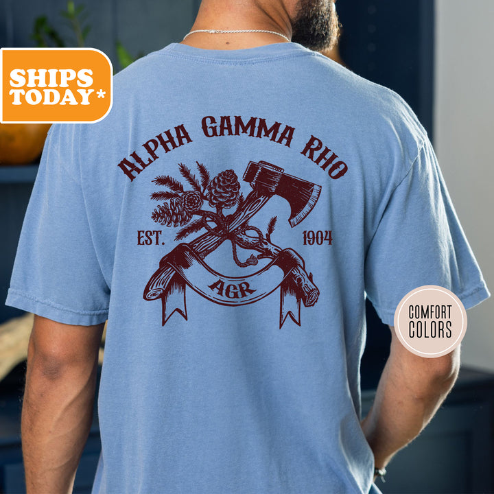 a man wearing a blue shirt with a hammer and pine cones on it