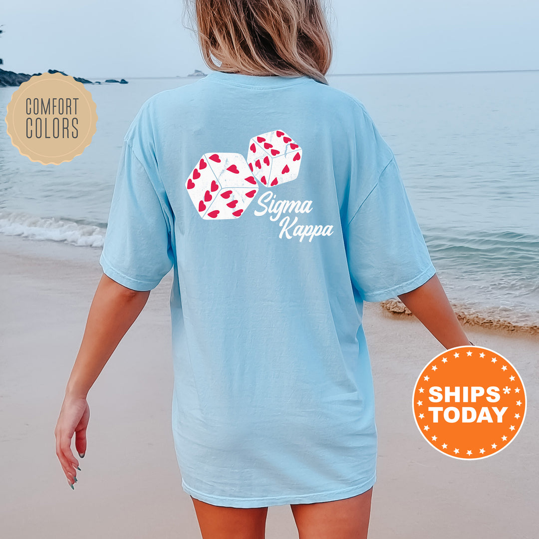 a woman walking on the beach wearing a blue shirt