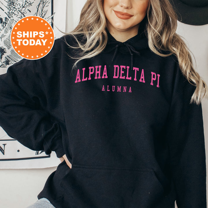 a woman wearing a black hoodie with pink letters