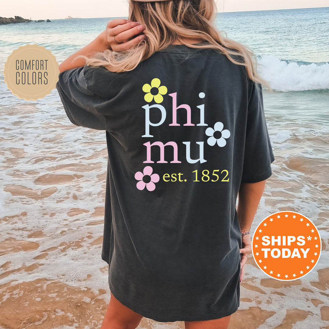 a woman standing on a beach wearing a phi nu shirt