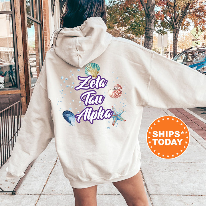 a woman walking down a sidewalk wearing a white hoodie
