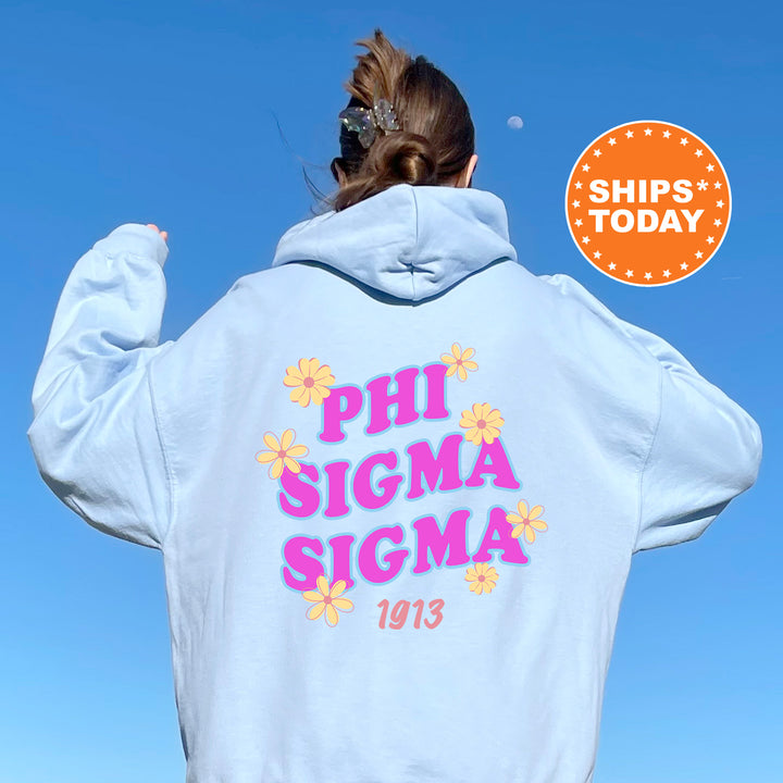 A person wearing a white hoodie with the text "PHI SIGMA SIGMA 1913" printed on it, standing against a clear blue sky.