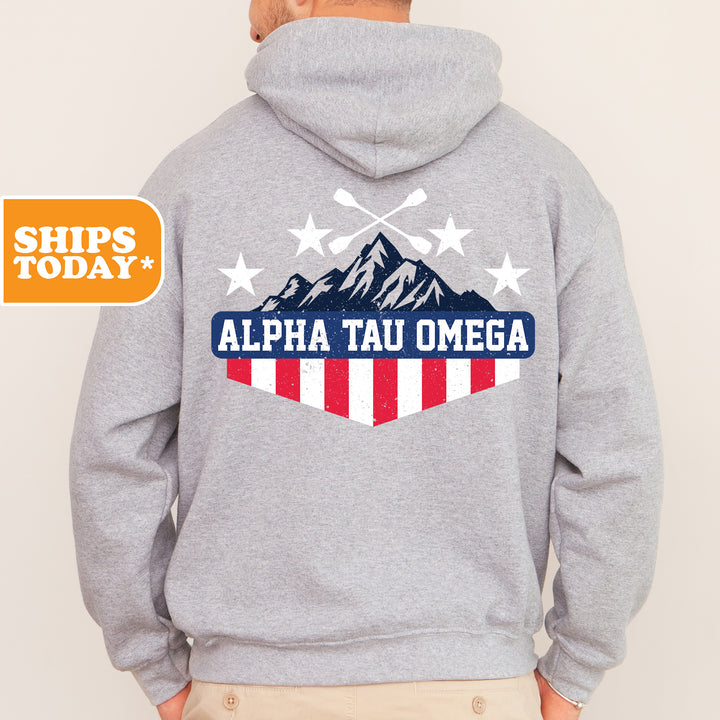 a man wearing a gray hoodie with an american flag on it