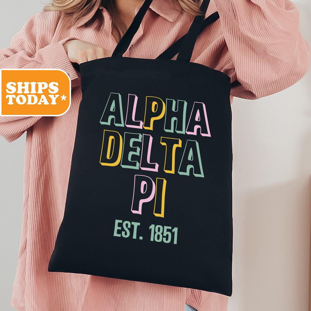 a woman is holding a black bag with the words delta pi on it